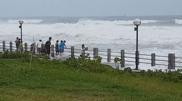 許多民眾今天下午到高雄旗津港口附近觀浪，就算海水已沖上堤防岸邊也不離開。（圖翻攝自爆料公社）