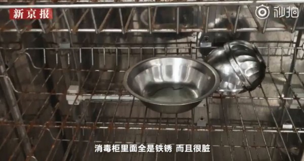 家長指出，小朋友放碗筷的消毒箱不僅髒還都生了鏽。（圖翻攝自《新京報-我們視頻》）
