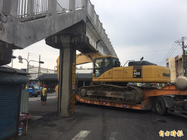 囧！拖板車載怪手卡陸橋。（記者邱芷柔攝）