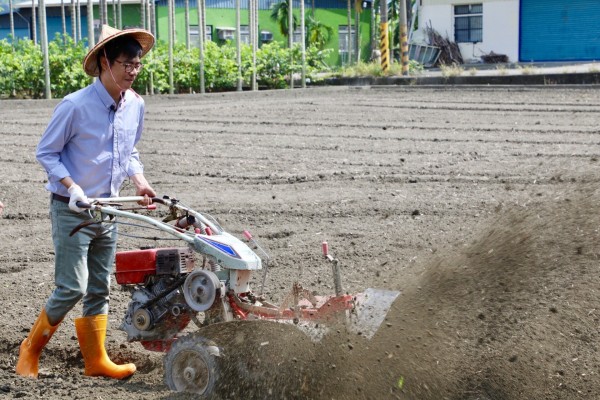 陳其邁推著播種機，體驗種植紅豆的辛苦。（記者葛祐豪翻攝）