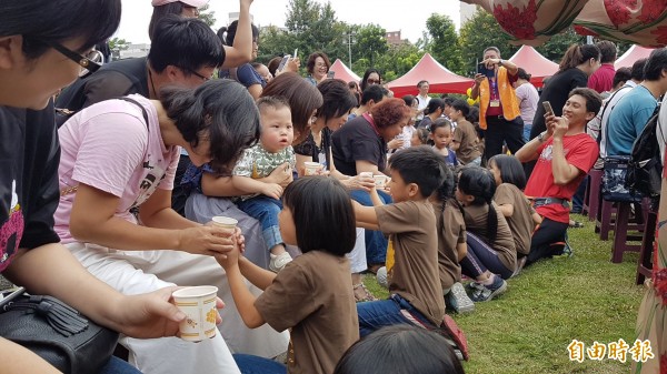 學童蹲跪奉茶。（記者黃旭磊攝）