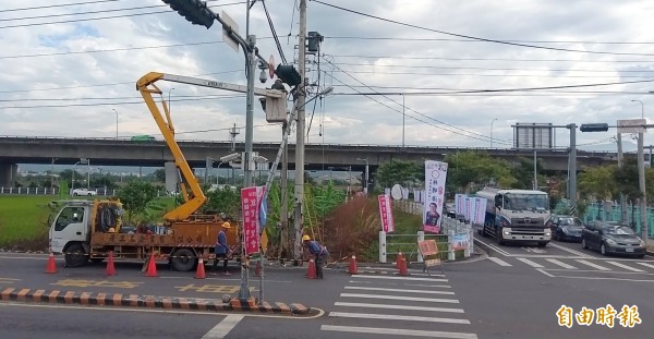 南投市華陽路旁電線桿遭小貨車撞到破一個大洞，且有傾倒之虞，台電公司人員緊急進行搶修。（記者謝介裕攝）