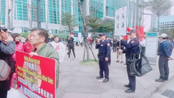 「德國舊馬克協會」高舉納粹旗幟抗議，警方舉牌警告。（翻攝資料照）