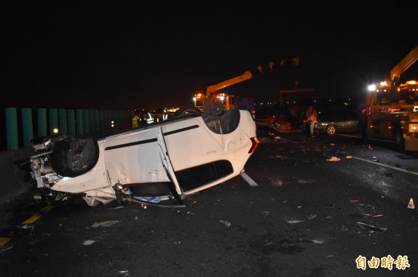 薛男的白車撞上曾男的車子後翻覆內側車道，曾男紅車又被後車撞上。（記者楊金城攝）