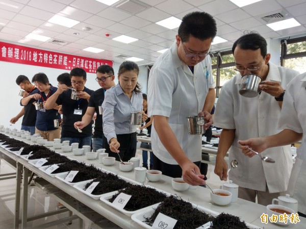 南投魚池鄉日月潭紅茶評鑑首見「母雞帶小雞」，由專業評審（白衣）帶著實習品評員試喝茶樣，利用實戰教學，傳授茶葉評鑑經驗。（記者劉濱銓攝）