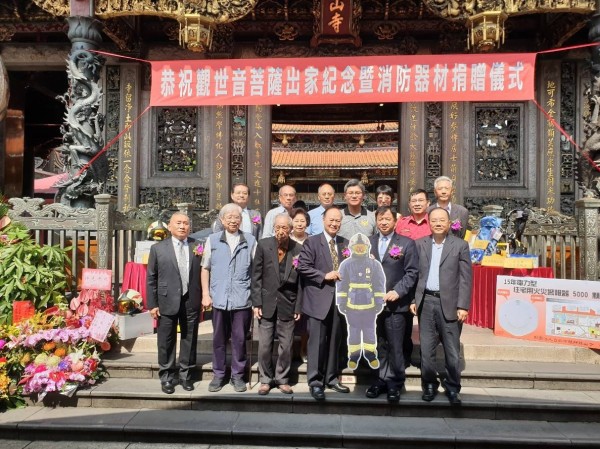 台北市艋舺龍山寺今天在觀世音菩薩出家紀念日捐贈新北市消防局市價800萬的消防衣帽鞋、潛水氣瓶與住宅火災警報器，新北市消防局由副局長陳崇岳（前排右2）、主任秘書陳國忠（前排右1）代表受贈。（記者吳仁捷翻攝）