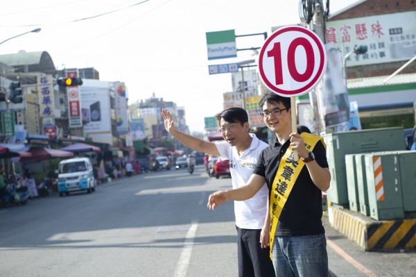 徐永明陪同吳韋達站在市場入口馬路旁向選民請託。（吳韋達競選總部提供）