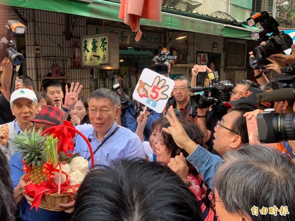 台北市長柯文哲收下象徵好彩頭的鳳梨跟蘿蔔。（記者沈佩瑤攝）