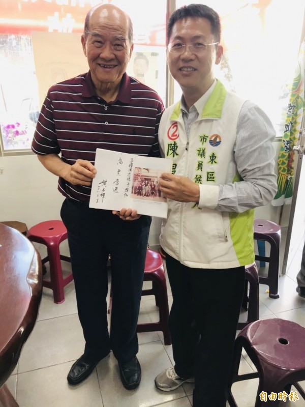 台聯黨前主席黃昆輝送自撰的著作書給南市東區市議員候選人陳昌輝。（記者王俊忠翻攝）