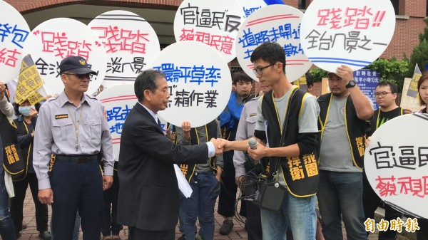 竹北市公所主秘張錦河（左）從大義里長候選人曾台安（右）手中接下反蓋納骨塔的陳情書。（記者黃美珠攝）