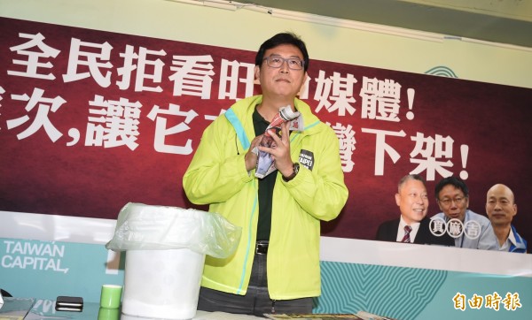 民進黨台北市長候選人姚文智召開記者會，呼籲全民拒看旺中媒體，讓旺中在台灣下架，並將報紙揉成一團丟入垃圾桶。（記者劉信德攝）