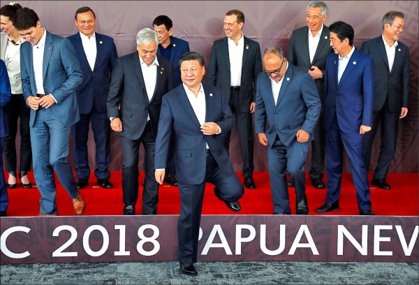 亞太經合會（APEC）各國領袖18日拍大合照，中國國家主席習近平好像主人，率先走下舞台。（路透）