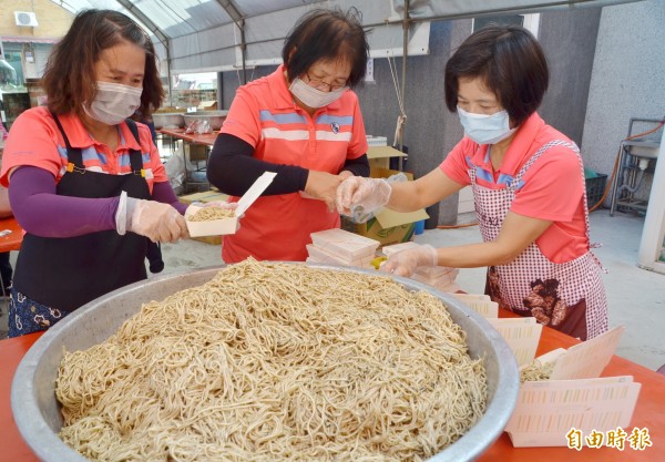 善化區農會提供芝麻拌麵品嚐，工作人員忙著準備。（記者吳俊鋒攝）