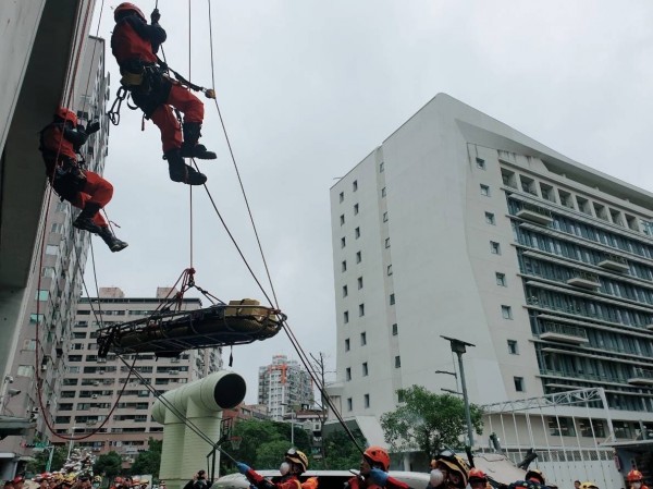 消防署今天召集全國136個災害防救團體進行聯繫會報，會場模擬車輛墜落山谷，由特搜人員展開吊掛等救災。（記者吳仁捷翻攝）