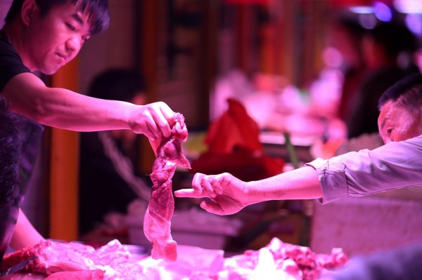中國民眾在攤販購買豬肉，圖僅為示意。（路透）