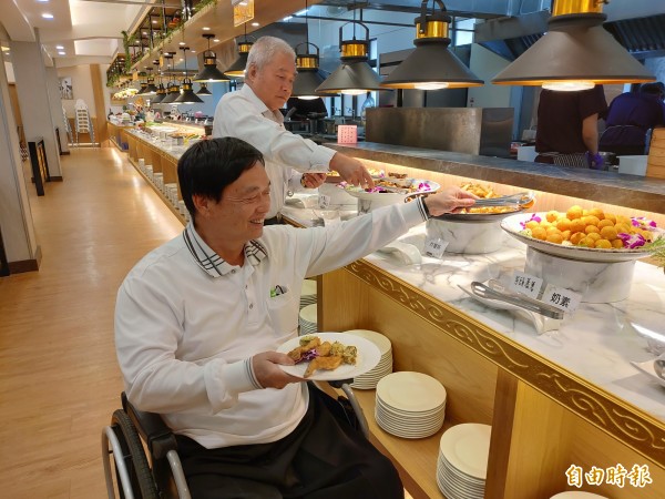 林亮暉（後）成立素食自助餐廳，吧檯降低設計，友善行動不便者取餐。（記者陳冠備攝）