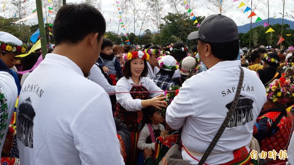 台東女議長吳秀華（中）在南王部落年祭中，為夫家長輩戴上花環。（記者黃明堂攝）