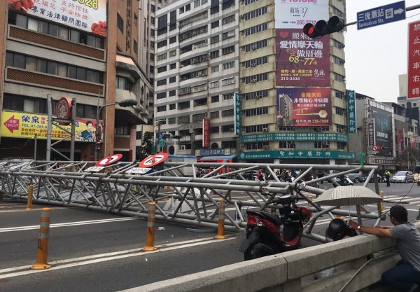 高雄中華地下道前巨型號誌鐵架掉落，機車騎士遭砸受傷。（記者黃良傑翻攝）