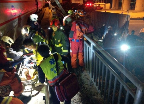 台中蘇姓男子今晚從高架橋跳鐵軌輕生，剛好被行經的自強橋號撞上，消防人員將他救出送醫。（記者陳建志翻攝）