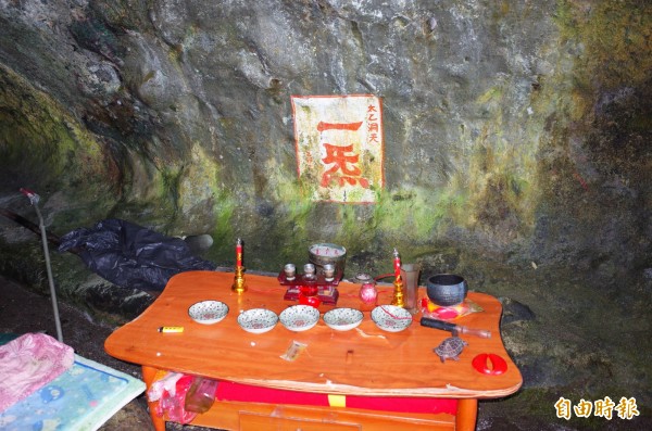 海蝕洞內被靈修人士以黃、紅色油漆,在千萬年形成的海蝕洞壁書寫「太乙洞天、一炁(氣的異體字)」等字樣,還有香案神壇祭拜。(記者花孟璟攝) 海蝕洞內被靈修人士以黃、紅色油漆,在千萬年形成的海蝕洞壁書寫「太乙洞天、一炁(氣的異體字)」等字樣,還有香案神壇祭拜。(記者花孟璟攝)