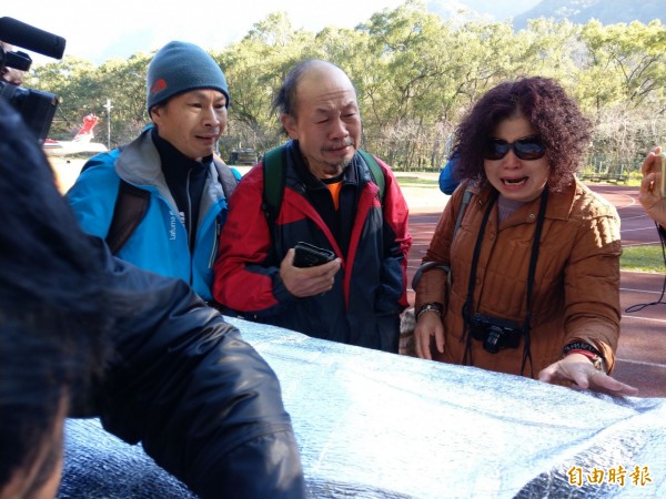 「比基尼登山客」的好友周業鎮（中）等人，看著吳女被抬下山，撫著遺體不禁痛哭。（記者劉濱銓攝）