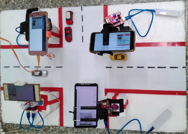 中興高中5名學生以4部手機，代表4個路口的鏡頭，救護車APP啟動後系統就會下指令，讓救護車通過的路口變綠燈。（中興高中提供）