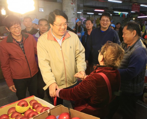 基隆市長林右昌（中）到市場拜年，祝賀攤商們生意興隆，也向採買民眾拜早年。（基隆市政府提供）