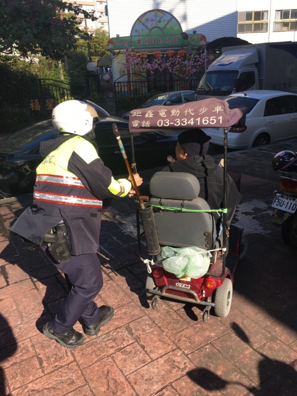 警方推著袁姓老翁的電動輔助車，助他平安返家。（記者周敏鴻翻攝）