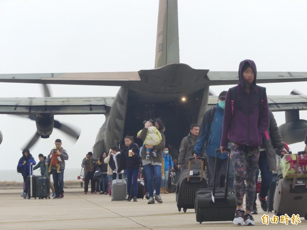 歸心似箭的旅客帶著過年行李，魚貫走下軍機。（記者吳正庭攝）