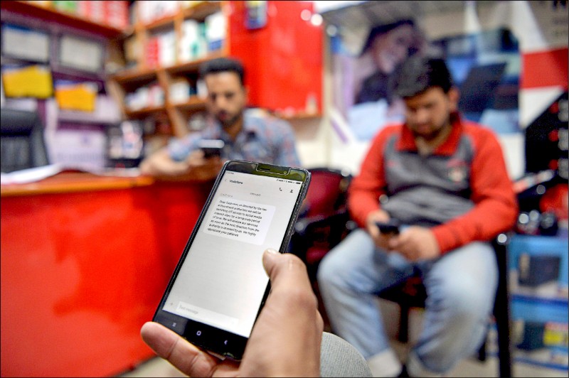 印度設在喀什米爾的行政當局於二○一七年四月二十六日，以「當地維安」為由，下令網路服務供應商阻擋網友連上臉書等社群媒體。圖為一名喀什米爾人於同年四月二十七日，在位於喀什米爾邦斯利那加的一間店使用智慧型手機上網。（法新社檔案照）