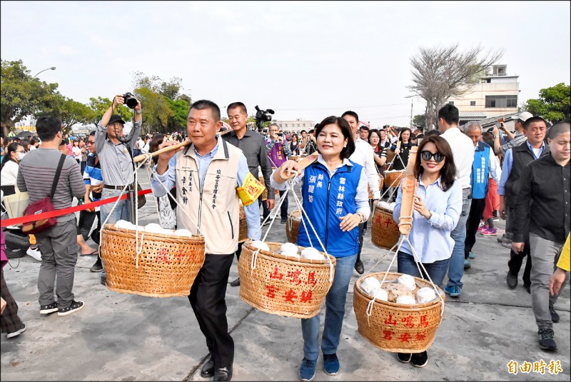 雲林褒忠鎮安宮五年千歲吃飯擔昨天登場，縣長張麗善與鎮安宮主委章金樹等人一起挑飯擔進入會場。（記者黃淑莉攝）