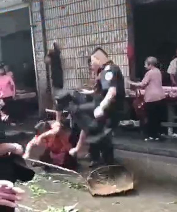 牧師高齡74歲的老母被員警毆打成傷，警方事後對女士摸頭。中國員警打人示意圖。（圖擷取自微博）