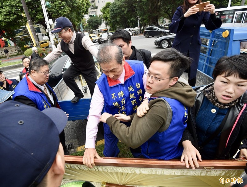 統促黨總裁張安樂今早率眾抬棺到立法院外抗議,摔落載棺貨車,被工作人員抱住,但整個抬棺行動警方三度舉牌警告。(記者羅沛得攝) 統促黨總裁張安樂今早率眾抬棺到立法院外抗議,摔落載棺貨車,被工作人員抱住,但整個抬棺行動警方三度舉牌警告。(記者羅沛得攝)