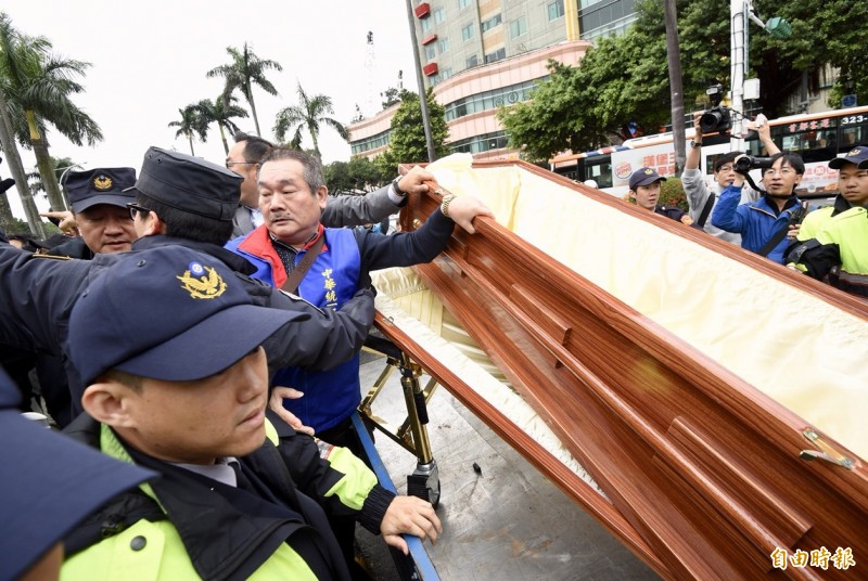 統促黨總裁張安樂今早率眾抬棺到立法院外抗議,警方三度舉牌警告。(記者羅沛德攝) 統促黨總裁張安樂今早率眾抬棺到立法院外抗議,警方三度舉牌警告。(記者羅沛德攝)