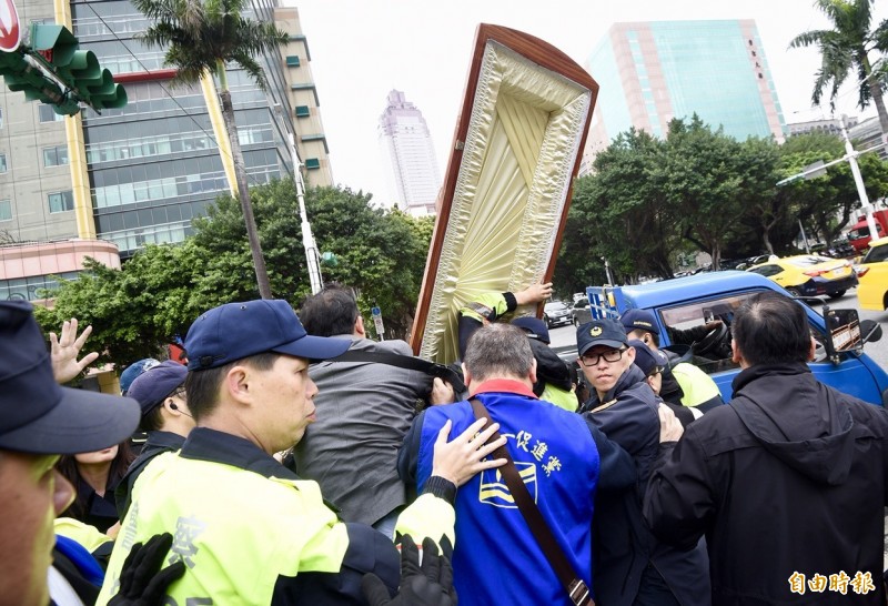 統促黨總裁張安樂今早率眾抬棺到立法院外抗議,警方三度舉牌警告。(記者羅沛德攝) 統促黨總裁張安樂今早率眾抬棺到立法院外抗議,警方三度舉牌警告。(記者羅沛德攝)