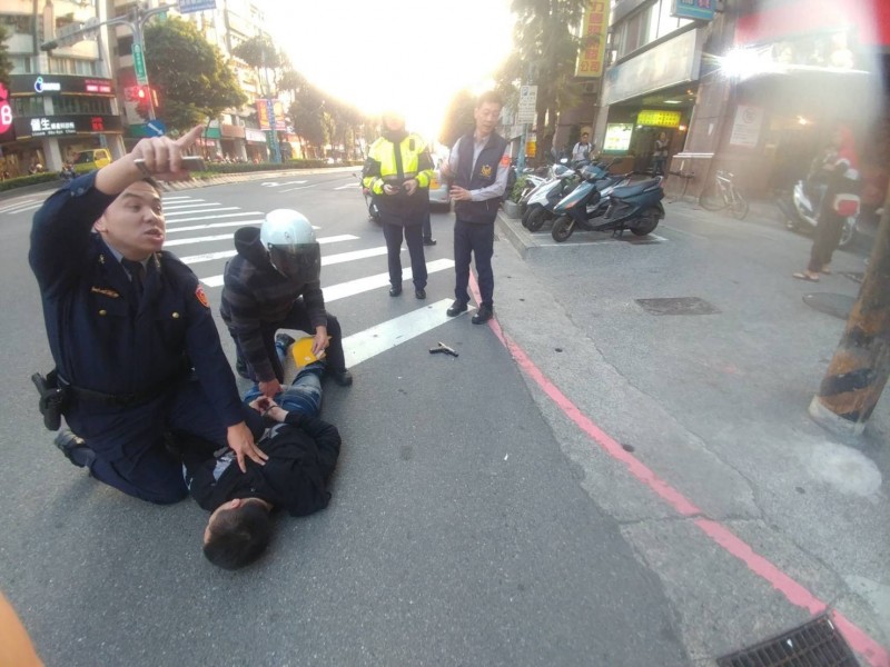 陳嫌遭線上警力壓制逮捕，持有的制式手槍掉落在一旁。（記者曾健銘翻攝）