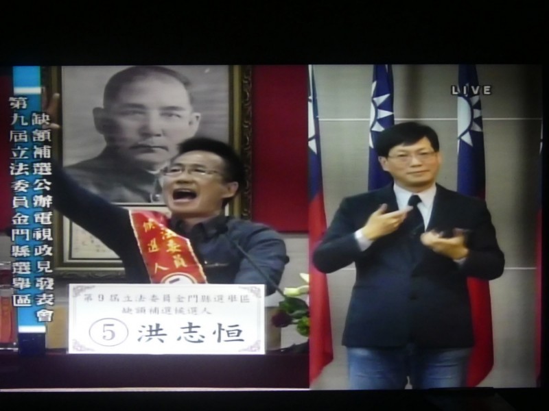 金門立委候選人洪志恒（左）發表政見「唱給你聽」，考驗一旁手語老師的臨場反應。（記者吳正庭翻攝）