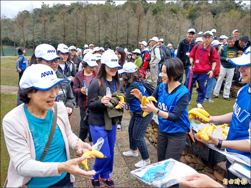 全日空旅遊公司在日月潭舉辦百人健行，現場發放南投集集山蕉，令日客相當欣喜。（記者劉濱銓攝）