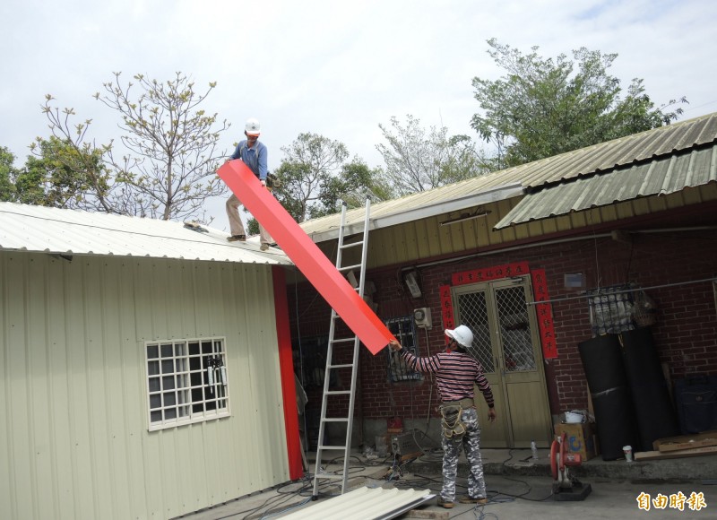 慈善團評估，在邱女娘家前方搭建一間無障礙空間的鐵皮屋，師傅們加緊趕工。（記者陳冠備攝）