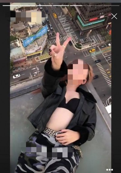 一名女子為拍美照，爬上台中SOGO頂樓留影，引起撻伐。（圖擷取自爆料公社）