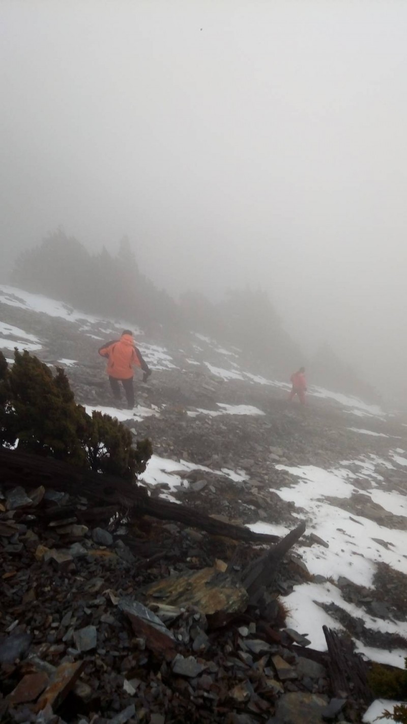 救難人員冒險在能見度只有5到10公尺濃霧中，在陡峭碎石坡尋找張姓男子大體。（花蓮縣消防局提供）