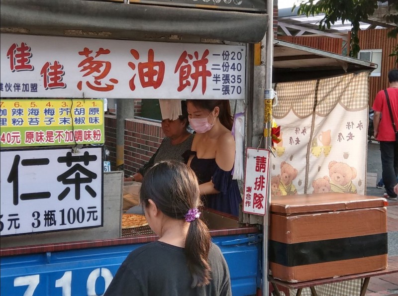 網友在高雄旗山老街閒逛時，看見女子穿著深藍色一字領低胸上衣賣蔥油餅。（擷取自爆廢公社）