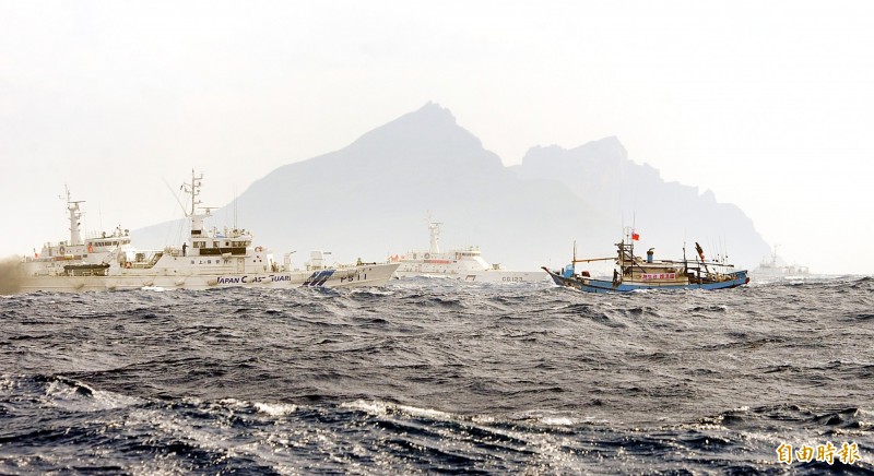 2012年9月25日台灣漁船挺進釣魚台，我國漁船（右）遭日本海上保安廳船艦（左，船身有3條藍色斜線）驅離，海巡署船艦（中，較遠處白色船身）立即趨近護航。（記者方賓照攝）