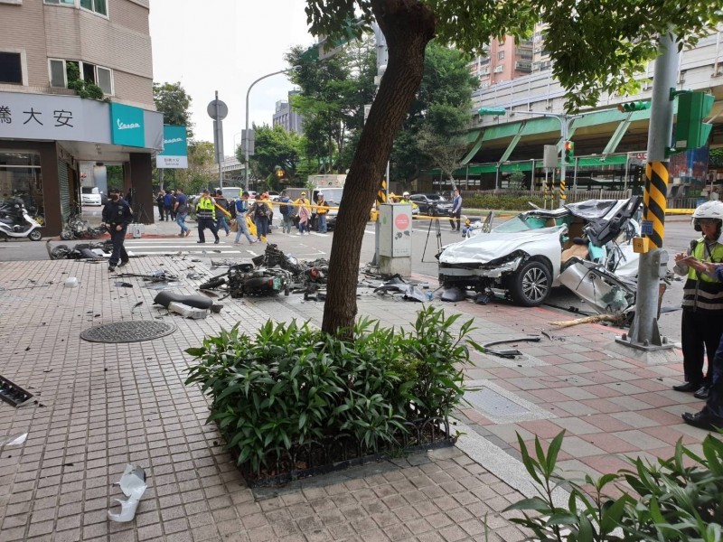 一輛白色休旅車上午9時許衝撞建國南路一段旁的人行道，掃倒路邊多輛機車。（記者姚岳宏翻攝）