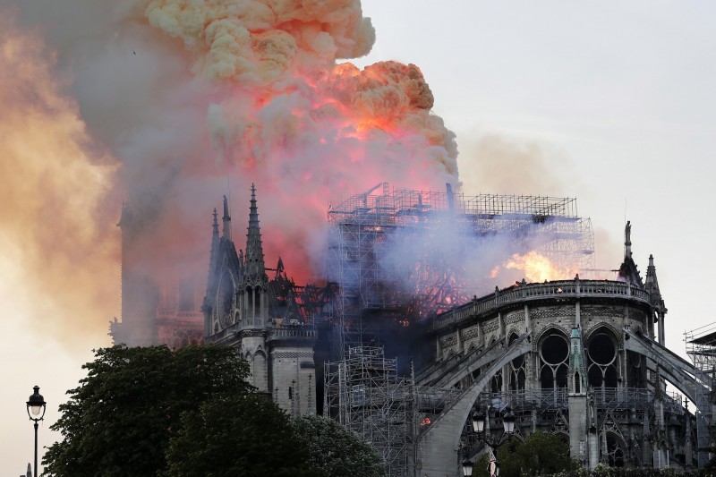法國巴黎著名古蹟「聖母院」發生大火，教堂尖塔及屋頂都遭到烈焰燒毀。（歐新社）