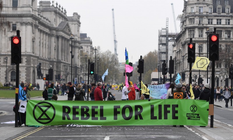 英國環保人士為了呼籲政府重視環保議題，在市中心進行示威遊行。（歐新社）