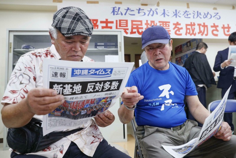 沖繩縣當地居民對駐日美軍非常不滿，圖為「是否贊成駐日美軍普天間基地遷徙」公投案隔日，當地居民閱讀開票結果。（美聯社）