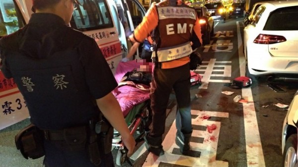 警、消人員救護遭人圍毆重創的陳姓男子，路面上血跡斑斑。（記者王俊忠攝）