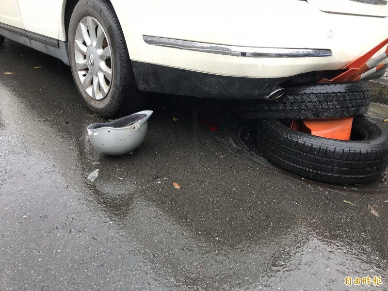 騎士的安全帽遺留在現場，車底下及安全帽旁還有騎士血跡。（記者吳昇儒攝）