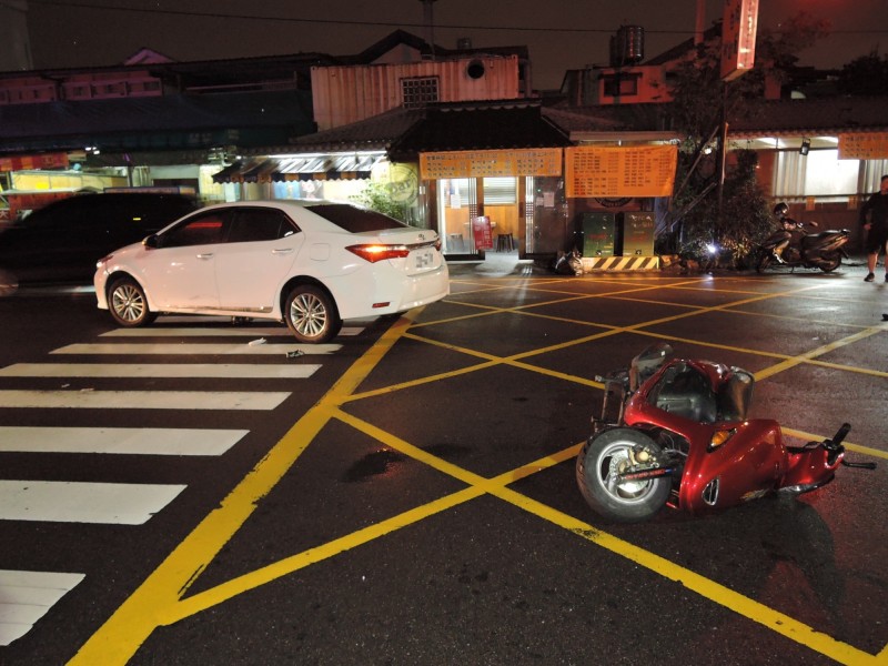 騎機車的張男滾入白色轎車的底下，送醫後有生命危險。（記者張瑞楨翻攝）